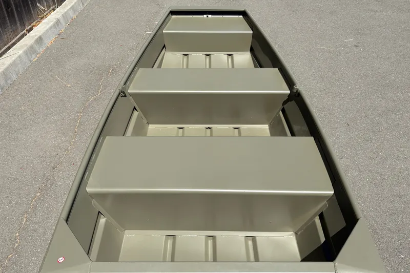 Slide: The Image of 2026 Tracker Grizzly 10 Jon boat with three bench seats on pavement. - 6