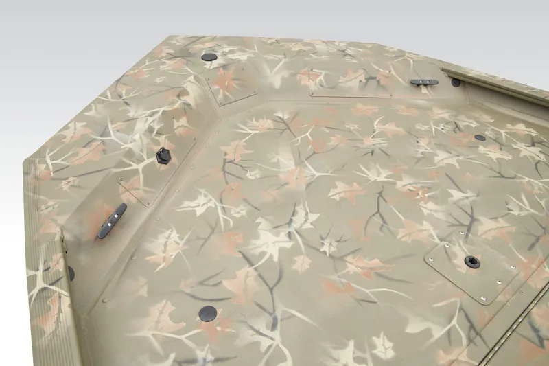 Slide: The Image of 2026 Tracker Grizzly 1754 SC boat with camouflage seats and steering wheel, docked outdoors. - 9