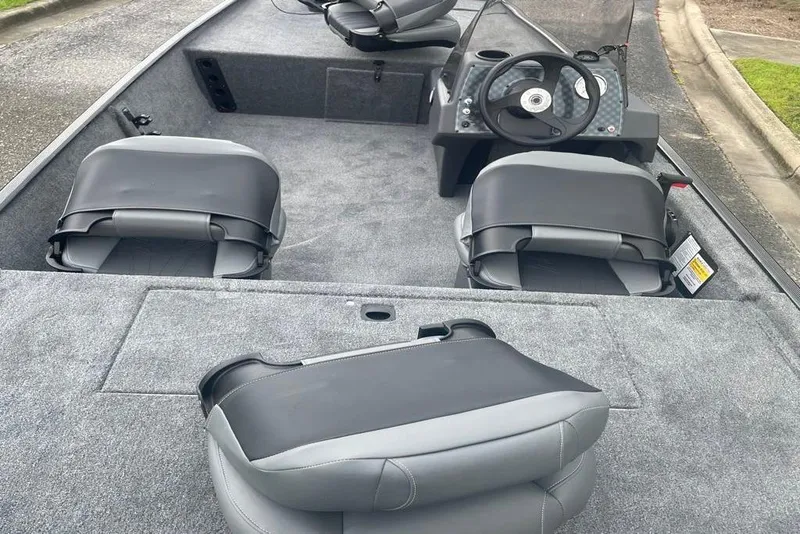 Slide: The Image of 2026 Tracker Bass Tracker Classic XL interior with gray seating and steering console. - 2