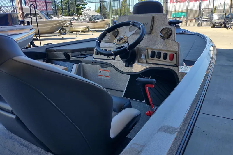 Slide: The Image of 2026 Nitro Z18 Pro boat interior with steering wheel and control panel, parked outdoors. - 3