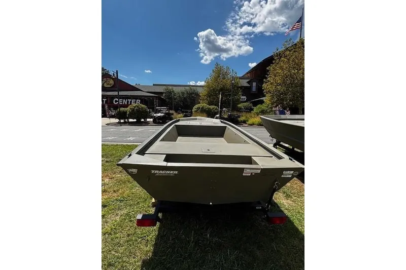 Slide: The Image of 2026 Tracker Grizzly 1648 Utility boat displayed outdoors under a sunny sky. - 2