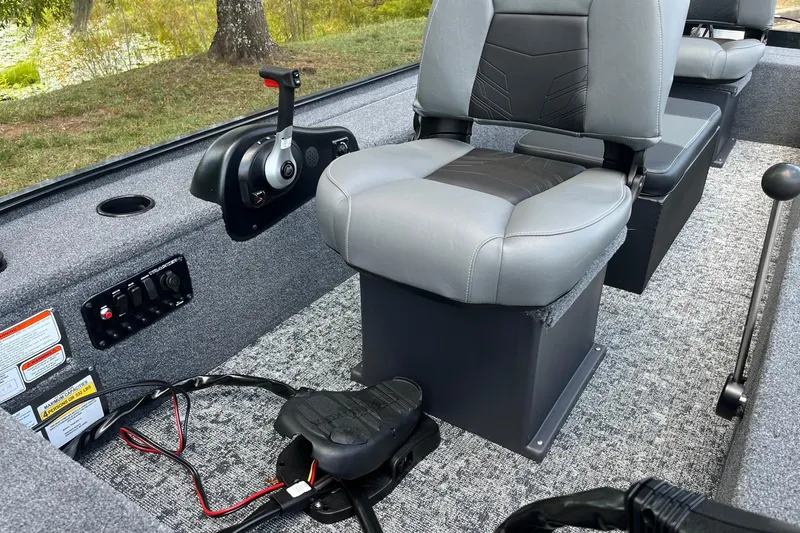 Slide: The Image of 2025 Tracker Panfish 17 boat interior with gray seating, control panel, and foot pedal. - 7