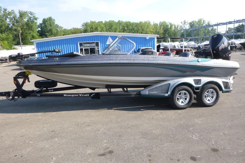Slide: The Image of 2024 Ranger 212LS boat on trailer outside showroom. - 4