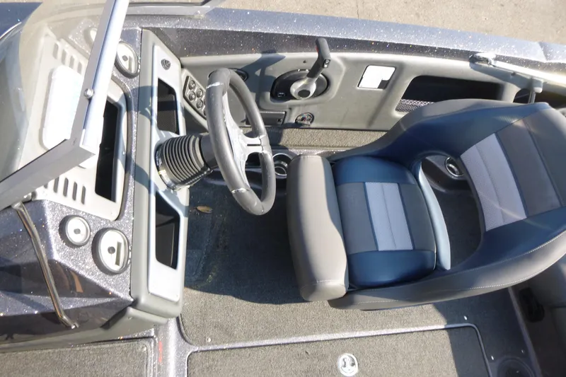 Slide: The Image of 2024 Ranger 212LS boat cockpit with steering wheel and cushioned seat. - 7