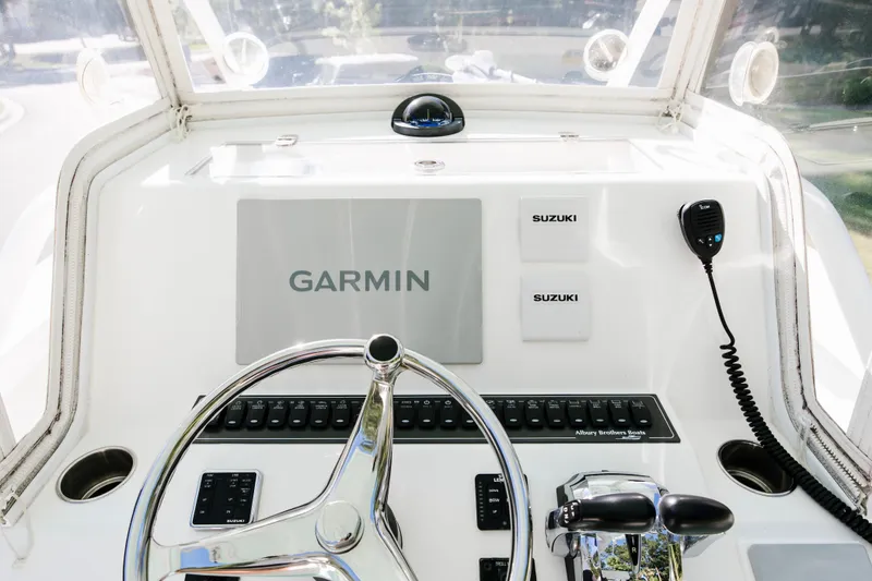 Slide: The Image of 2017 Albury Brothers center console boat dashboard with Garmin and Suzuki controls. - 11