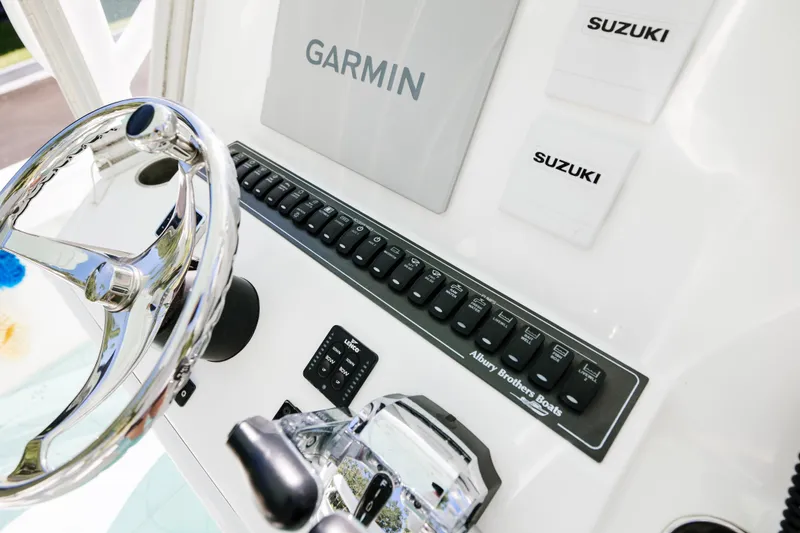 Slide: The Image of 2017 Albury Brothers center console boat dashboard with Garmin and Suzuki controls. - 16