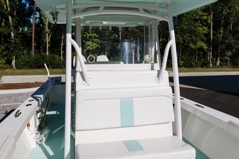 Slide: The Image of 2017 Albury Brothers center console boat with white seating and teal accents, docked outdoors. - 31