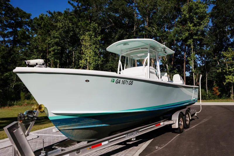 Slide: The Image of 2017 Albury Brothers center console boat on trailer, surrounded by trees. - 4