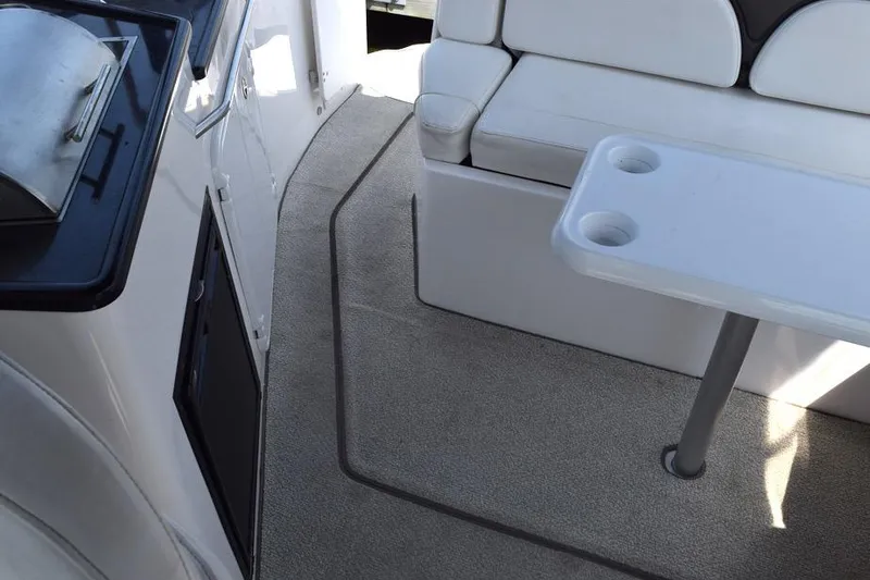 Slide: The Image of 2010 Rinker 310 Express Cruiser interior with seating and table setup. - 10