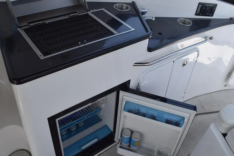 Slide: The Image of 2010 Rinker 310 Express Cruiser kitchenette with grill and mini fridge. - 15