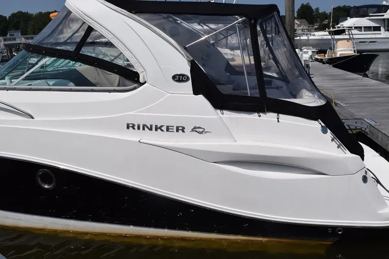 Slide: The Image of 2010 Rinker 310 Express Cruiser docked at marina, side view. - 2