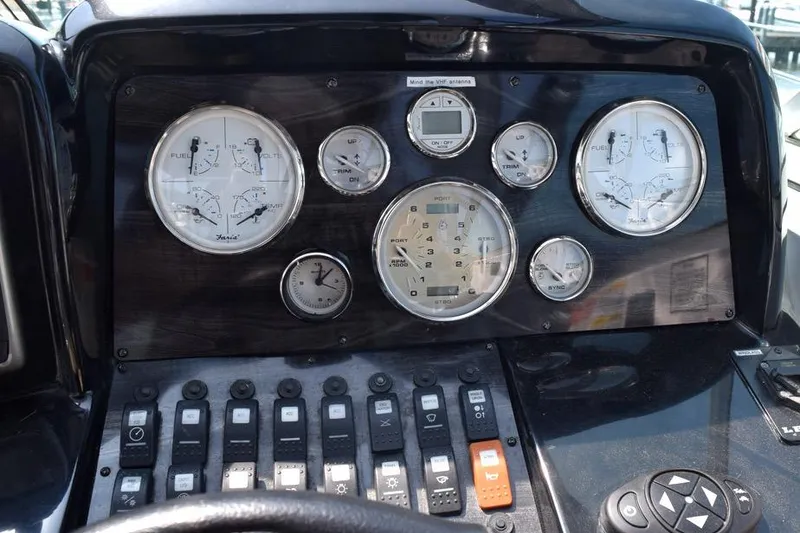 Slide: The Image of Control panel of a 2010 Rinker 310 Express Cruiser with gauges and switches. - 20