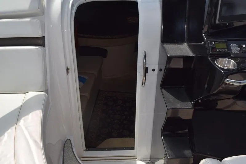 Slide: The Image of 2010 Rinker 310 Express Cruiser cabin entrance with seating and control panel. - 25