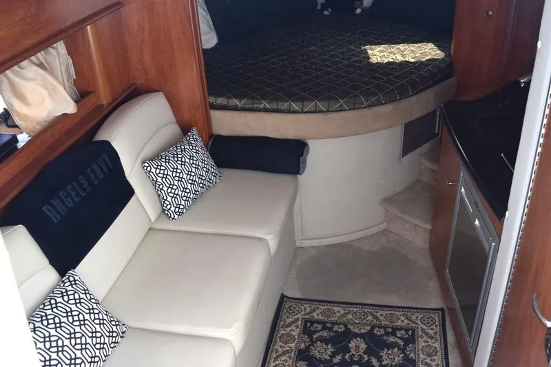 Slide: The Image of 2010 Rinker 310 Express Cruiser interior with sofa, bed, and kitchenette. - 26