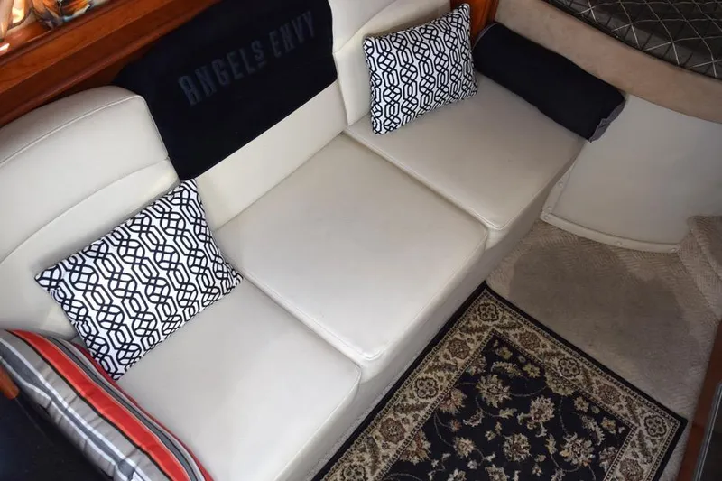 Slide: The Image of 2010 Rinker 310 Express Cruiser interior with white seating and patterned cushions. - 27