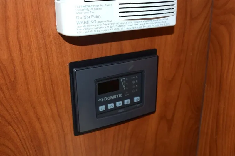 Slide: The Image of Control panel and alarm on 2010 Rinker 310 Express Cruiser's wooden interior. - 37