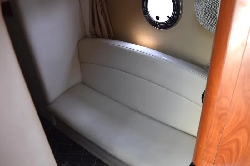 Slide: The Image of Interior of 2010 Rinker 310 Express Cruiser with white leather seating and porthole window. - 38