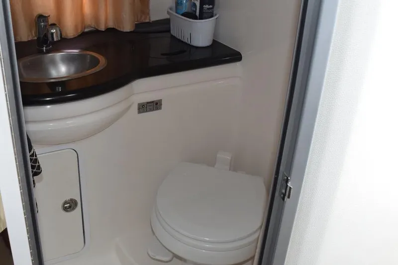 Slide: The Image of 2010 Rinker 310 Express Cruiser bathroom with sink and toilet. - 41