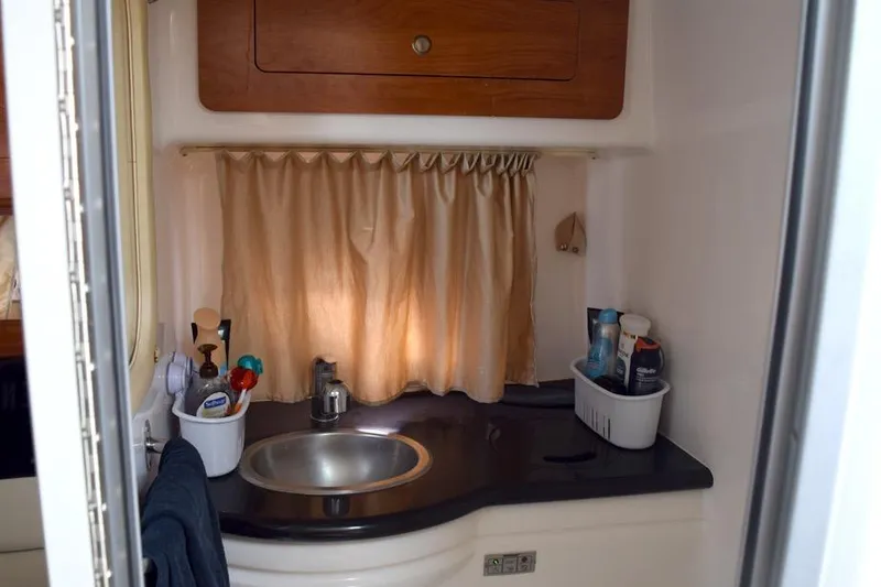 Slide: The Image of 2010 Rinker 310 Express Cruiser bathroom with sink, toiletries, and curtain. - 42