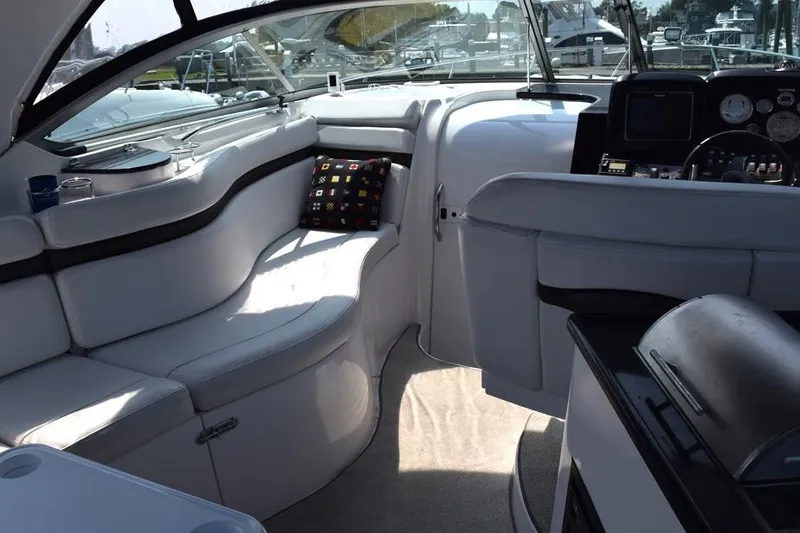 Slide: The Image of 2010 Rinker 310 Express Cruiser interior with plush seating and modern dashboard. - 6