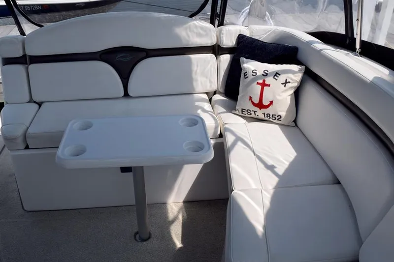 Slide: The Image of 2010 Rinker 310 Express Cruiser interior with white seating and Essex-themed pillow. - 8