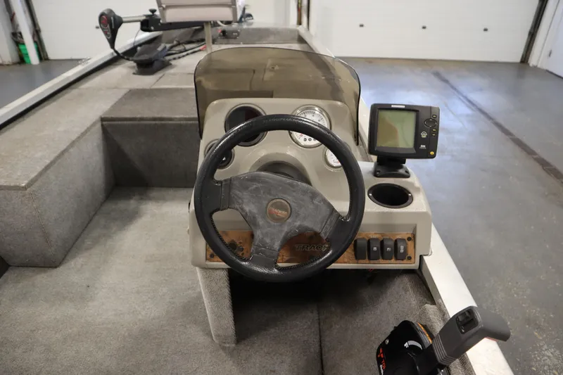 Slide: The Image of 1997 Tracker 18 Pro Team SC boat dashboard with steering wheel and fish finder. - 24