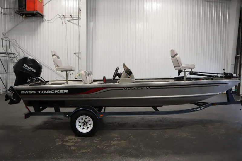 Slide: The Image of 1997 Tracker 18 Pro Team SC bass boat with Tohatsu motor in a garage setting. - 4