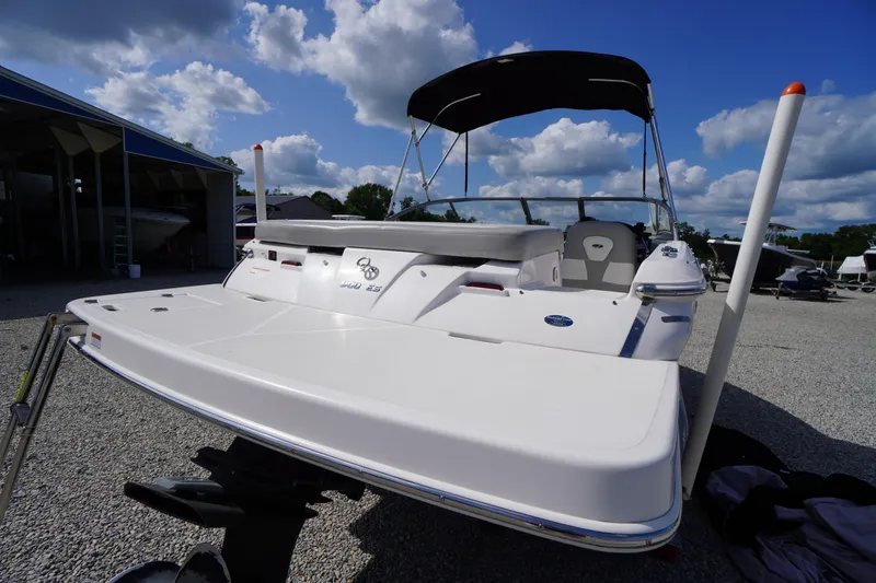 Slide: The Image of 2019 Regal 1900 ES Bowrider boat with canopy, parked outdoors under a blue sky. - 23
