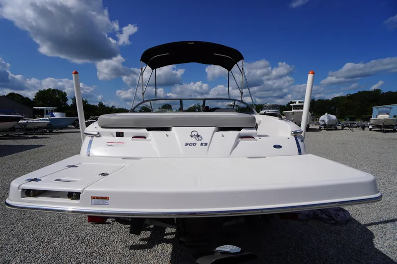 Slide: The Image of 2019 Regal 1900 ES Bowrider boat, rear view, parked on gravel under blue sky. - 26