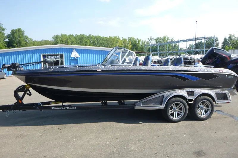 Slide: The Image of 2024 Ranger 621FS Pro boat on trailer, parked outside a blue showroom. - 4