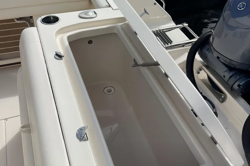 Slide: The Image of 2022 Grady-White Canyon 271 boat interior with storage compartment and engine detail. - 14
