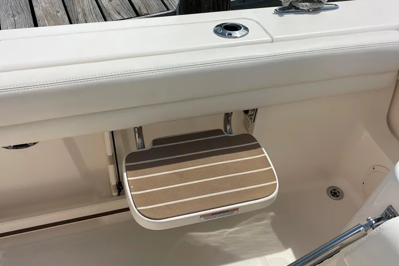 Slide: The Image of 2022 Grady-White Canyon 271 boat with a foldable wooden step and white seating. - 16