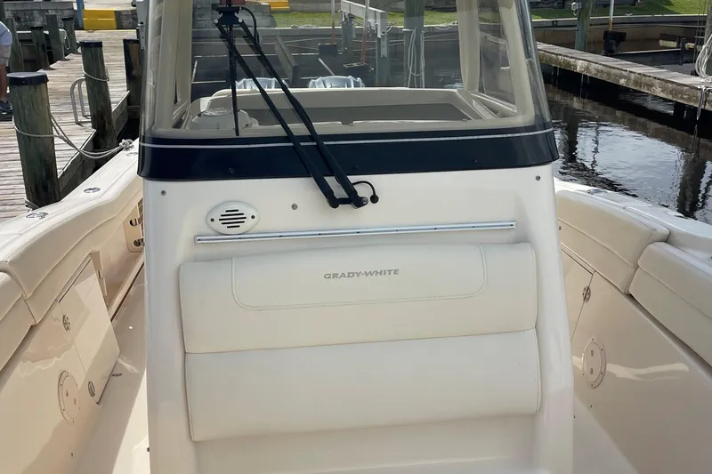 Slide: The Image of 2022 Grady-White Canyon 271 boat at dock, showcasing helm and seating area. - 24