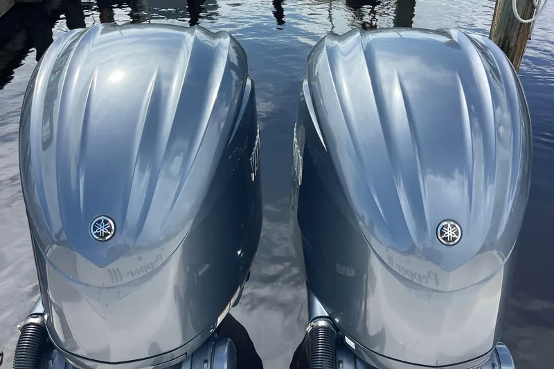Slide: The Image of Twin Yamaha outboard engines on a 2022 Grady-White Canyon 271 boat, docked on water. - 8