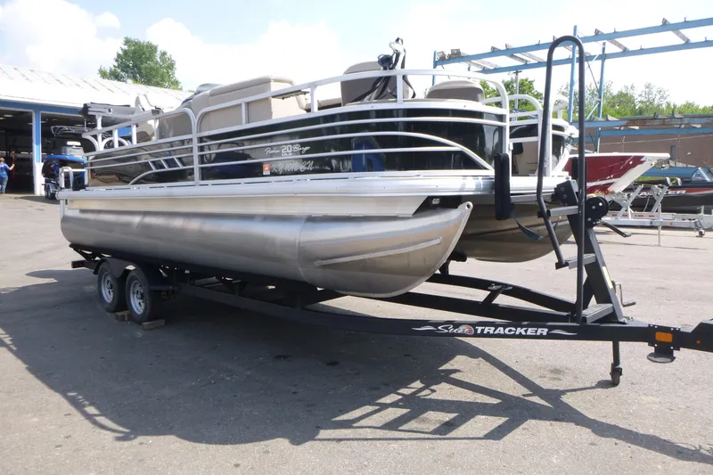 Slide: The Image of 2022 Sun Tracker Fishin' Barge 20 DLX pontoon boat on trailer in outdoor setting. - 3