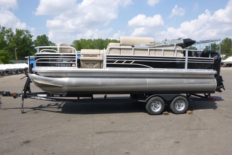 Slide: The Image of 2022 Sun Tracker Fishin' Barge 20 DLX pontoon boat on trailer, parked outdoors. - 4
