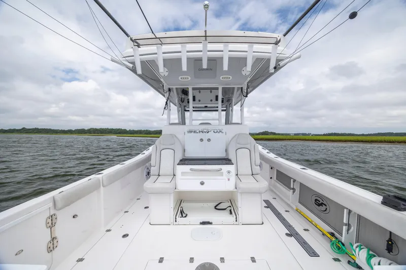 Slide: The Image of 2022 Sea Fox 368 Commander boat interior with seating, open water view, and overcast sky. - 25