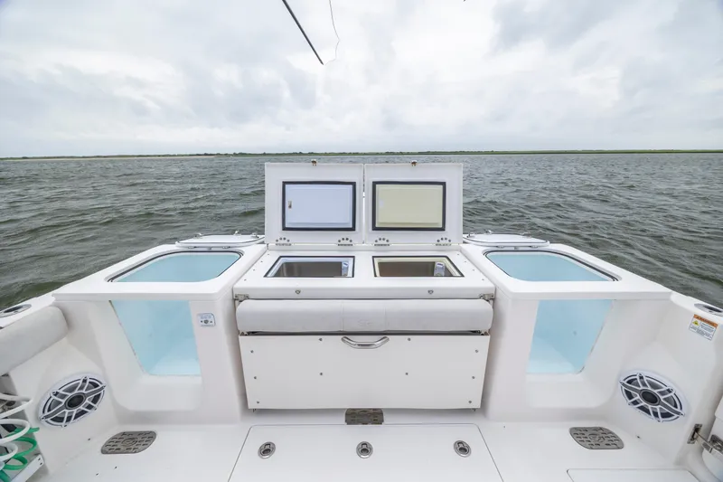 Slide: The Image of 2022 Sea Fox 368 Commander boat deck with open storage compartments on the water. - 33