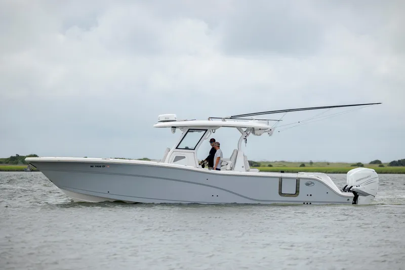 Slide: The Image of 2022 Sea Fox 368 Commander boat on water, side view, with two people onboard. - 7