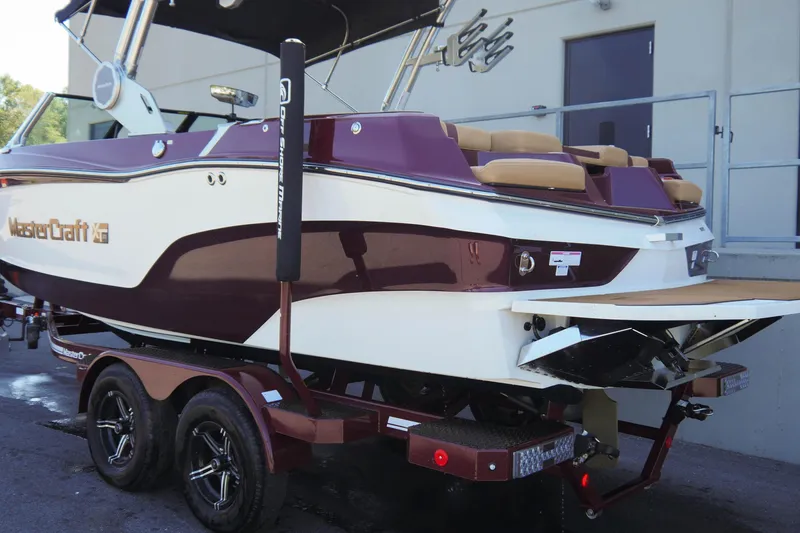 Slide: The Image of 2023 MasterCraft XT20 boat on trailer, featuring maroon and white design. - 4