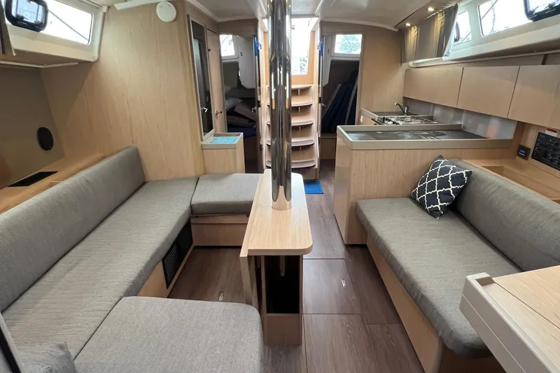 Slide: The Image of 2019 Beneteau Oceanis 41.1 interior with modern wood finish and cozy seating area. - 5