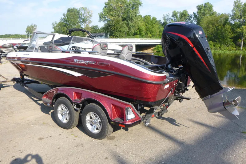 Slide: The Image of 2024 Ranger 2080MS boat on trailer, red and white, parked near water. - 3