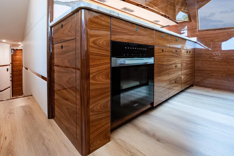 Slide: The Image of Luxurious kitchen interior of 2025 Viking 64 Convertible yacht with wood cabinetry and modern appliances. - 34