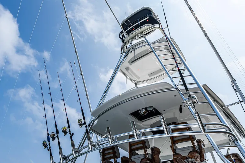 Slide: The Image of 2025 Viking 64 Convertible yacht with fishing rods against a blue sky. - 37