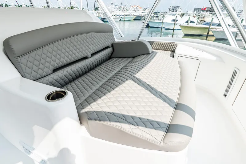 Slide: The Image of Luxurious seating on 2025 Viking 64 Convertible yacht, featuring quilted upholstery and cup holder. - 38