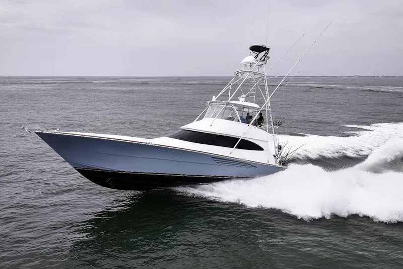 Slide: The Image of 2026 Viking 64 Convertible yacht cruising swiftly on open water. - 4