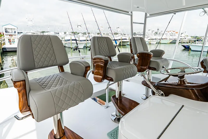 Slide: The Image of Luxurious seating on 2025 Viking 64 Convertible yacht with elegant design and marina view. - 47