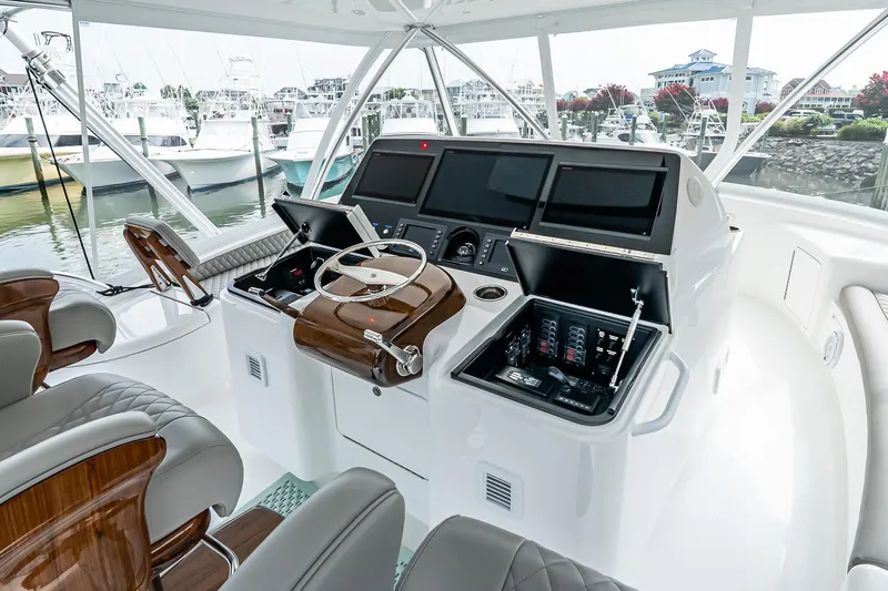 Slide: The Image of 2025 Viking 64 Convertible yacht helm with advanced navigation systems and luxurious seating. - 49