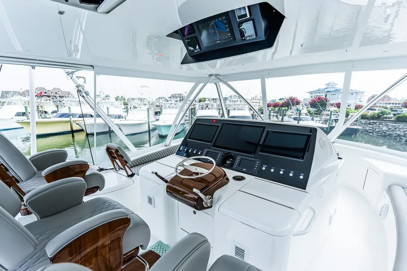 Slide: The Image of Luxurious 2025 Viking 64 Convertible yacht helm with advanced navigation systems and plush seating. - 50