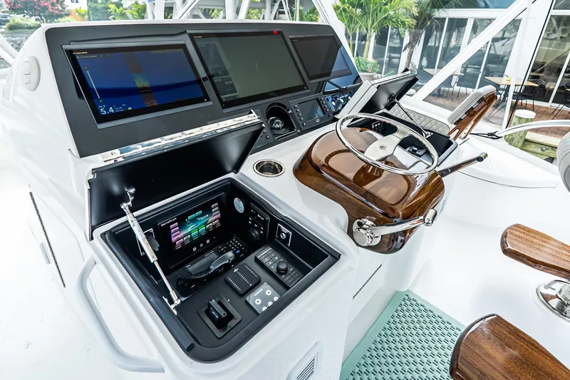 Slide: The Image of 2025 Viking 64 Convertible yacht helm with advanced navigation controls and sleek design. - 54